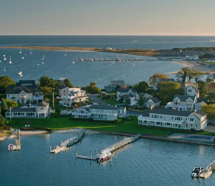 Birds eye view of small piers in front of houses in the town of Cape Cod.