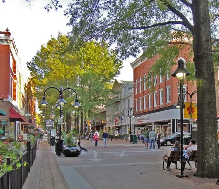 People walking and sitting on benches at a pedestrian street in Charlottesville, Virginia